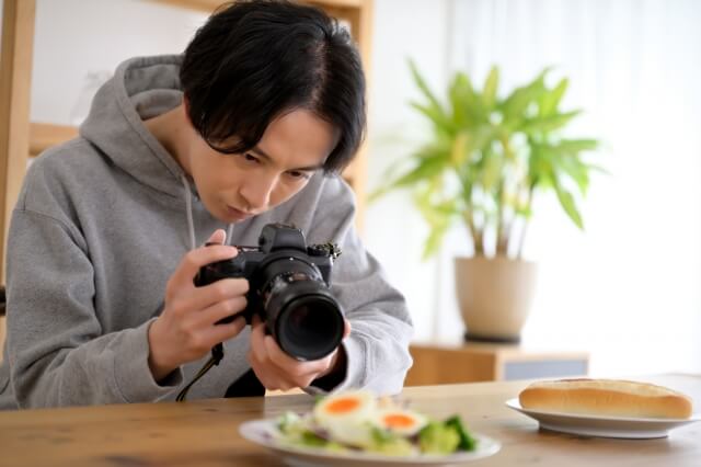 料理の写真を撮る男性