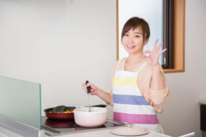 お気に入りの鍋とフライパンで調理する女性