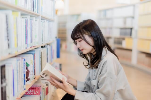 図書館で本を探している女性